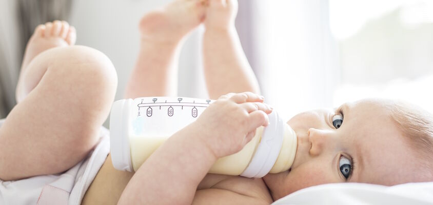 Baby trinkt Milch aus einer Babyflasche