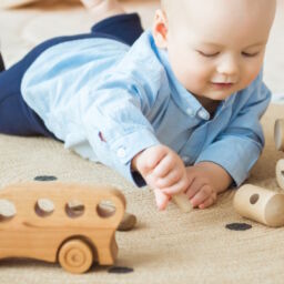 Baby spielt mit Holzspielzeug